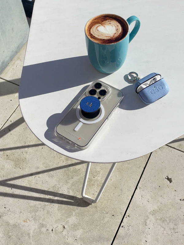 pop socket phone holder on a table next to airpods case